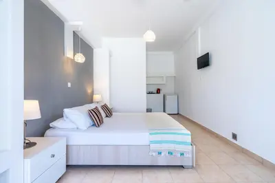 a white bedroom with a large bed in a room at Mando Living -Faliraki in Faliraki