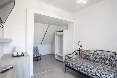 a room with a bed and two chairs at Mando Living -Faliraki in Faliraki