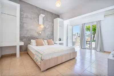 a bedroom with a large bed and a balcony at Mando Living -Faliraki in Faliraki