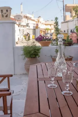 a wooden table with a bottle and two glasses on it at Anastasia's Home in Émbonas