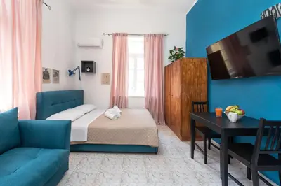 a bedroom with a bed and a couch and a table at Palm Residence lll - Islander's Home Collection in Rhodes Town