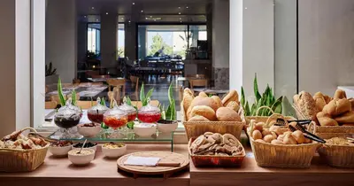 a table filled with breads and baskets of food at Blue Sea Holiday Village in Afantou