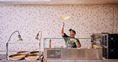 a woman is holding up a heart in a kitchen at Blue Sea Holiday Village in Afantou