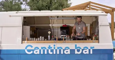 a man standing inside of a food truck at Blue Sea Holiday Village in Afantou