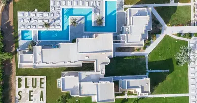 an aerial view of a white house with a swimming pool at Blue Sea Holiday Village in Afantou