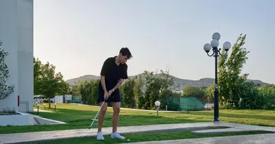 a man is playing golf in a park at Blue Sea Holiday Village in Afantou
