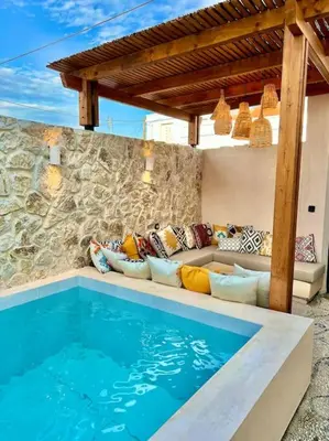 a living room with a couch and a swimming pool at Katoikía Pateliá in Koskinou