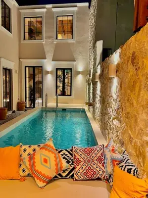 a swimming pool in a house with pillows next to it at Katoikía Pateliá in Koskinou