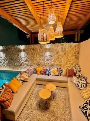 a room with a couch with pillows and a stool at Katoikía Pateliá in Koskinou