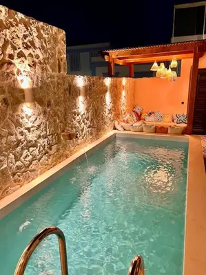 a large swimming pool with a stone wall at Katoikía Pateliá in Koskinou