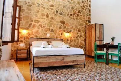 a bedroom with a bed and a stone wall at Meandros Suite in Old Town in Rhodes Town