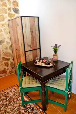 a table with two chairs and a plate of food on it at Meandros Suite in Old Town in Rhodes Town