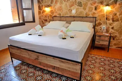 a bedroom with a large bed with shoes on it at Meandros Suite in Old Town in Rhodes Town