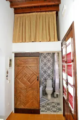 a bathroom with a toilet and a wooden door at Meandros Suite in Old Town in Rhodes Town