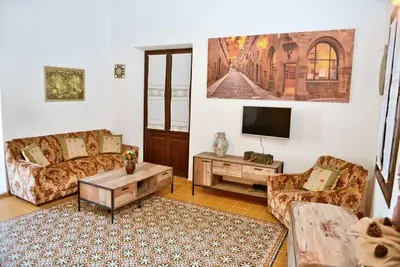 a living room with couches and a flat screen tv at Meandros Suite in Old Town in Rhodes Town