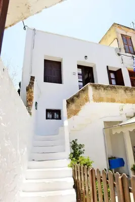 a white house with stairs leading up to it at Meandros Suite in Old Town in Rhodes Town