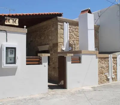 a building with white doors and a sign on it at M&M STONE-Village House-Family-Vintage in Líndos