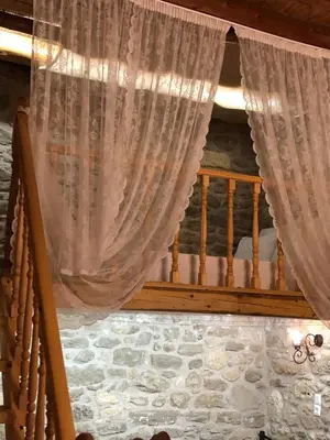 a curtain in a room with a bed and a balcony at M&M STONE-Village House-Family-Vintage in Líndos