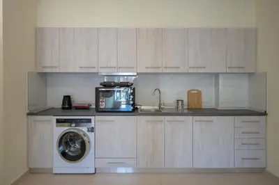 a kitchen with a washing machine and a microwave at Eden Lily- Luxurious Apartment with Sea View in Rhodes Town