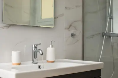 a bathroom sink with a mirror and a shower at Eden Lily- Luxurious Apartment with Sea View in Rhodes Town