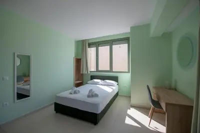 a bedroom with a bed and a desk and a mirror at Eden Lily- Luxurious Apartment with Sea View in Rhodes Town