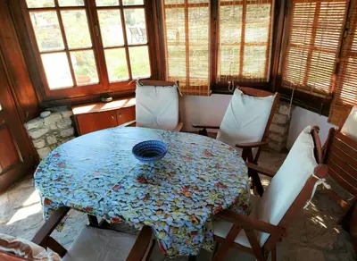 a dining room with a table and chairs and windows at The WindMill in Skala