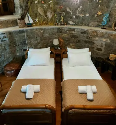 two beds in a room with towels on them at The WindMill in Skala
