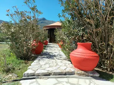 a row of red vases sitting on a stone path at The WindMill in Skala