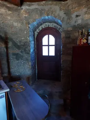 a kitchen with a wooden table and a door at The WindMill in Skala