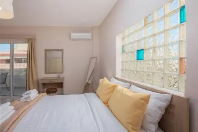 a bedroom with a bed and a large window at Bon Bonheur apartments in Rhodes Town