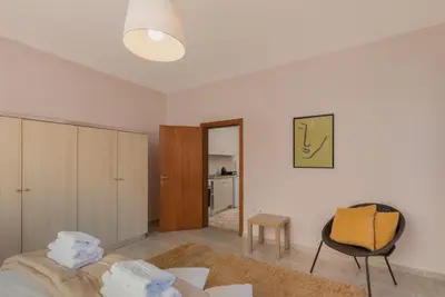 a bedroom with a bed and a chair in a room at Bon Bonheur apartments in Rhodes Town