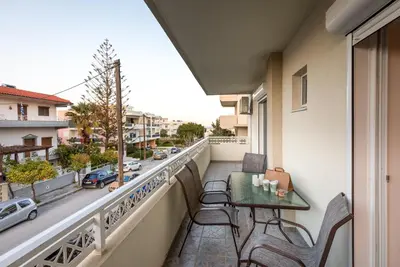 a balcony with a table and chairs and a street at Bon Bonheur apartments in Rhodes Town