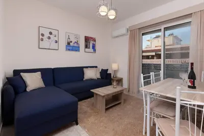 a living room with a blue couch and a table at Bon Bonheur apartments in Rhodes Town