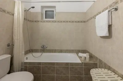 a bathroom with a bath tub and a toilet at Bon Bonheur apartments in Rhodes Town