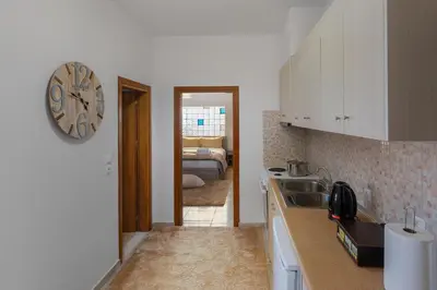 a kitchen with a sink and a clock on the wall at Bon Bonheur apartments in Rhodes Town