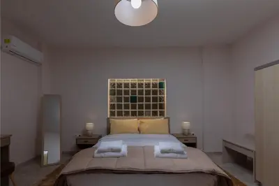 a bedroom with a large bed in a white room at Bon Bonheur apartments in Rhodes Town