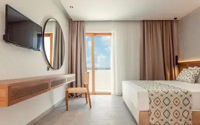 a hotel room with a bed and a mirror at Blue Sea Island in Kolimbia