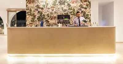 a man standing behind a bar in a room at Blue Sea Island in Kolimbia