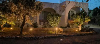 a house with lights in front of it at night at Chrysa Apartments in Kolimbia
