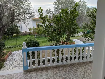 a blue and white fence in front of a yard at Chrysa Apartments in Kolimbia