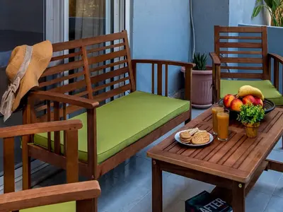 a chair and a table with a bowl of fruit at Aleanna Cozy Luxury Apartments in Rhodes Town