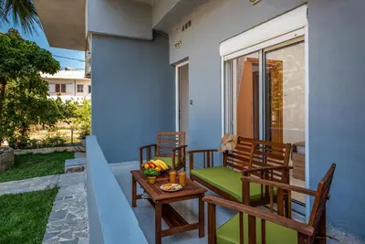 a porch with two chairs and a table with fruit on it at Aleanna Cozy Luxury Apartments in Rhodes Town