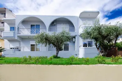 a white house with trees in front of it at Aleanna Cozy Luxury Apartments in Rhodes Town