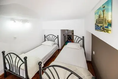 two beds in a room with white walls and wooden floors at Haraki Elegant View in Haraki