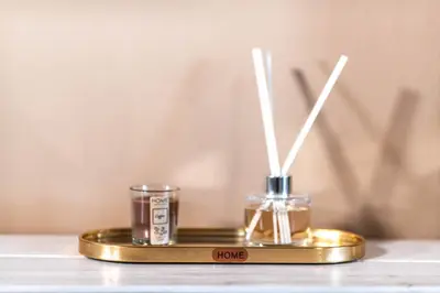 two candles on a gold plate on a table at Haraki Elegant View in Haraki