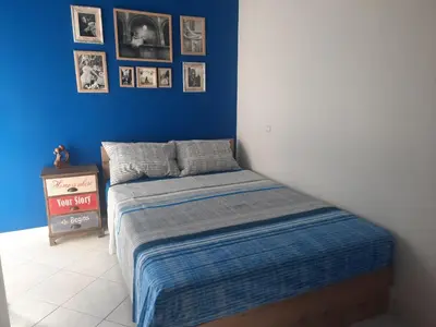 a bedroom with a bed with a blue wall at Maisonnete Lilian in Rhodes Town