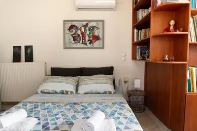 a small bedroom with a bed and book shelves at Maisonnete Lilian in Rhodes Town