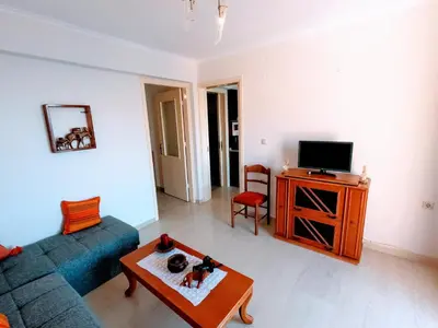 a living room with a blue couch and a tv at Villa Astradeni Symi in Symi