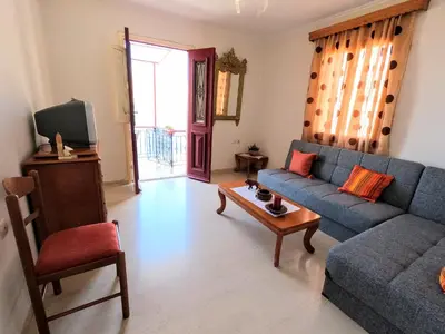 a living room with a blue couch and a table at Villa Astradeni Symi in Symi