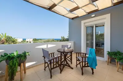 a patio with a table and chairs on a balcony at Villa Olvia in Gennadi